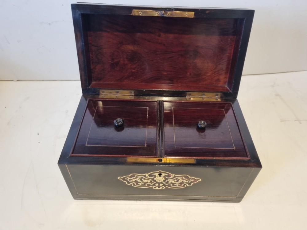 A rectangular ebonised wood tea caddy featuring a lid ornamented with red tortoiseshell and brass Boulle marquetry and a brass-inlaid keyhole escutcheon on the front. View VIII