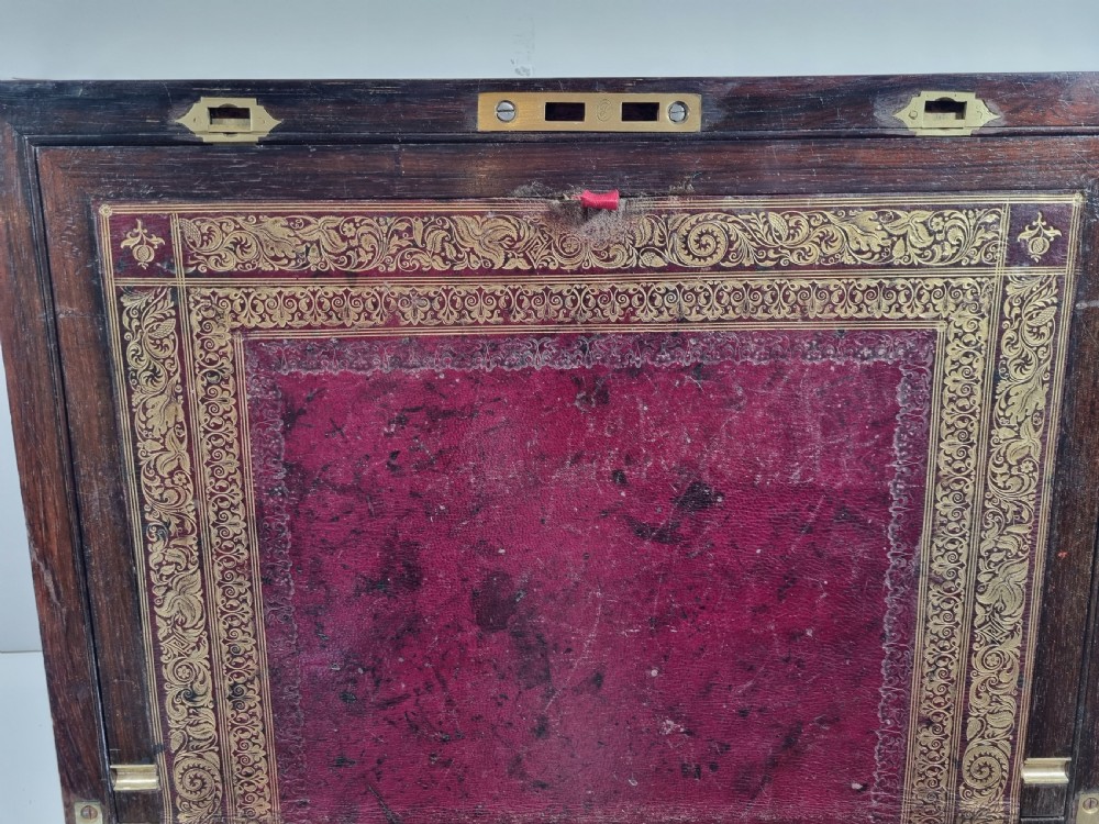 A rectangular dark rosewood writing box featuring intricate brass floral scrollwork inlay around the borders and escutcheon, complete with a key and tassel. View X
