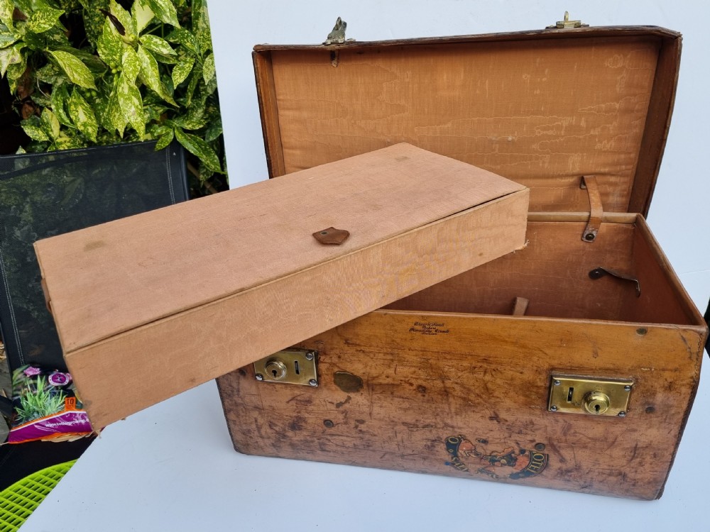 A Victorian tan leather travel trunk featuring hand-stitched edges, brass lever locks, a top carrying handle, and patinated surface wear. View XIV