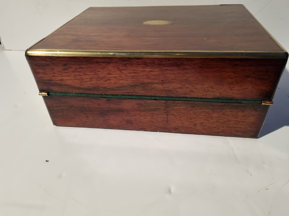 A rectangular dark rosewood document box featuring brass edge binding, an oval brass keyhole escutcheon, and an oval brass top inlay. View V