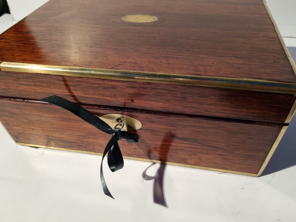 A rectangular dark rosewood document box featuring brass edge binding, an oval brass keyhole escutcheon, and an oval brass top inlay. View X