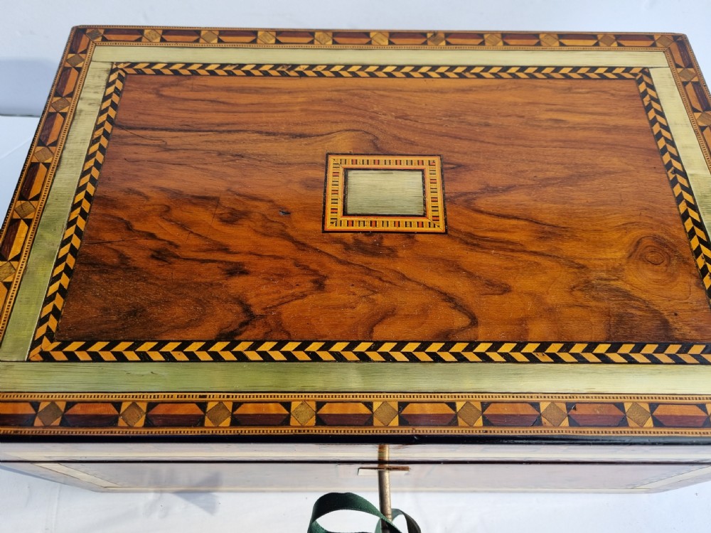 A rectangular Victorian walnut writing box with intricate geometric parquetry inlay borders and a central brass keyhole. View II