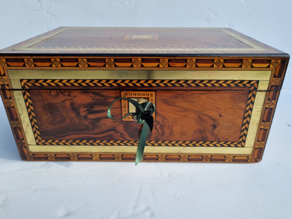 A rectangular Victorian walnut writing box with intricate geometric parquetry inlay borders and a central brass keyhole. View III