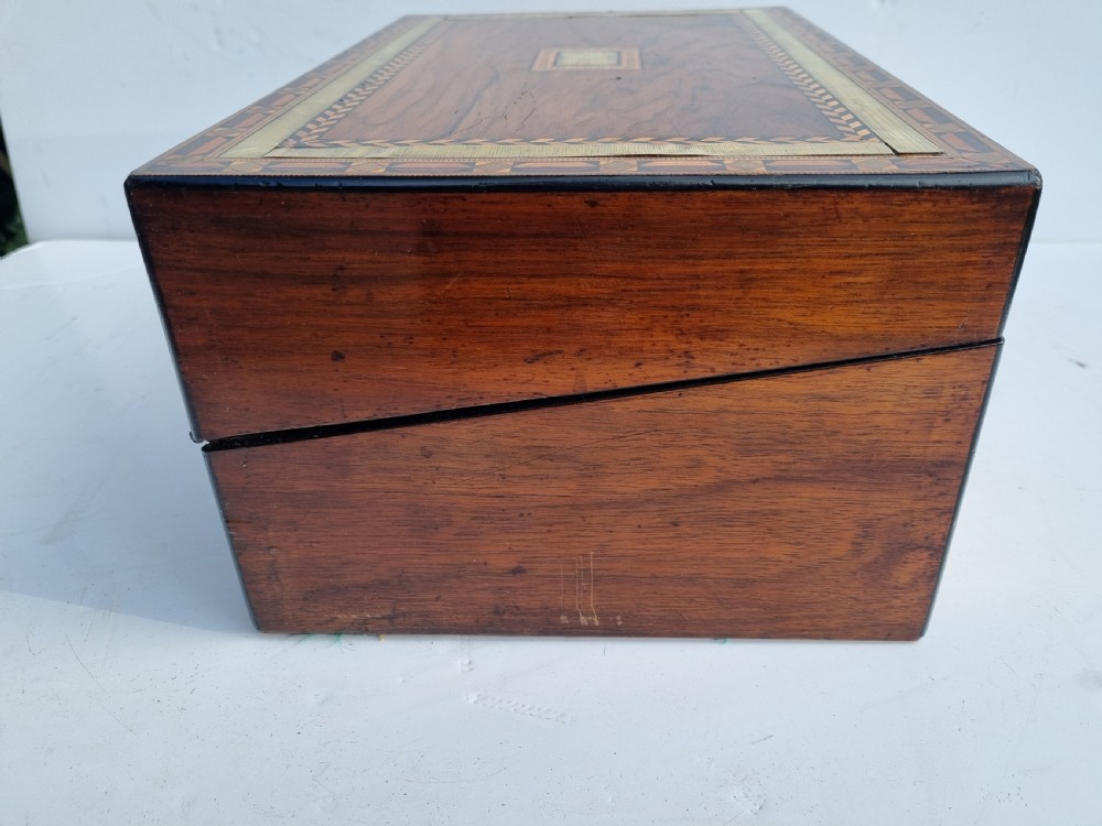 A rectangular Victorian walnut writing box with intricate geometric parquetry inlay borders and a central brass keyhole. View VII