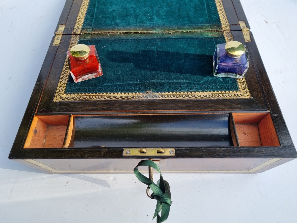A rectangular Victorian walnut writing box with intricate geometric parquetry inlay borders and a central brass keyhole. View IX
