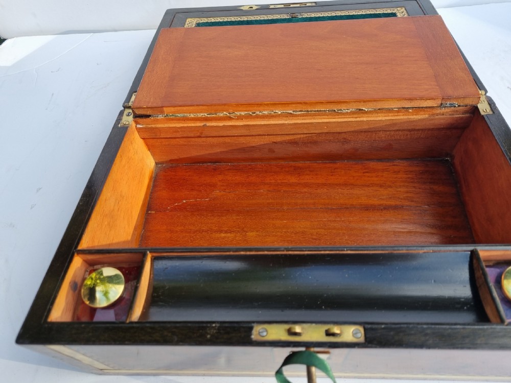 A rectangular Victorian walnut writing box with intricate geometric parquetry inlay borders and a central brass keyhole. View X