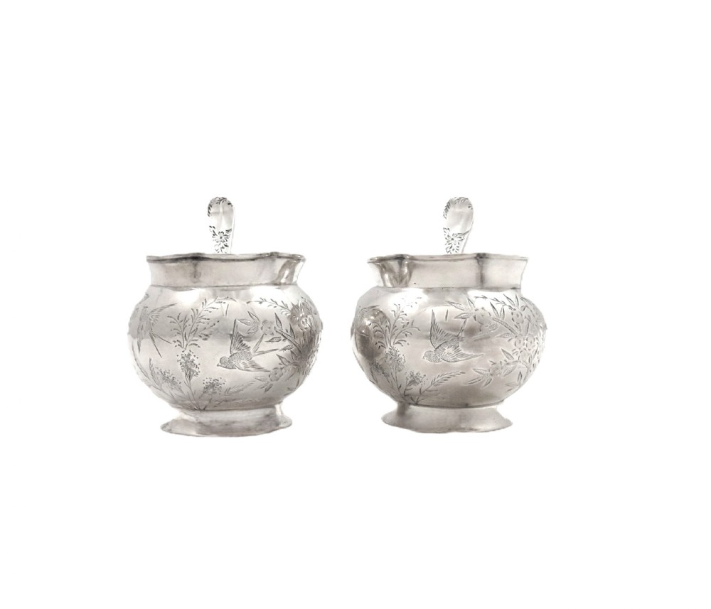 A pair of Victorian engraved sterling silver salt cellars with matching spoons displayed inside an open fitted purple silk-lined presentation case. View III