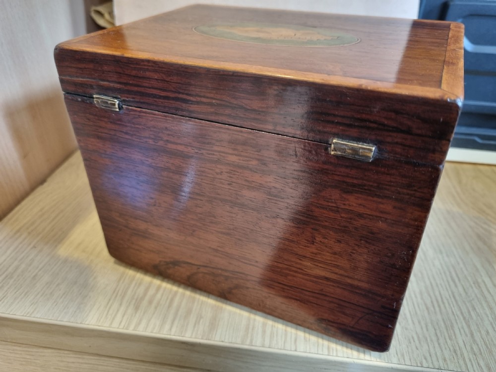 A rectangular dark rosewood tea caddy featuring a lid inlaid with an oval shell motif and a diamond-shaped bone keyhole escutcheon on the front face. View IV