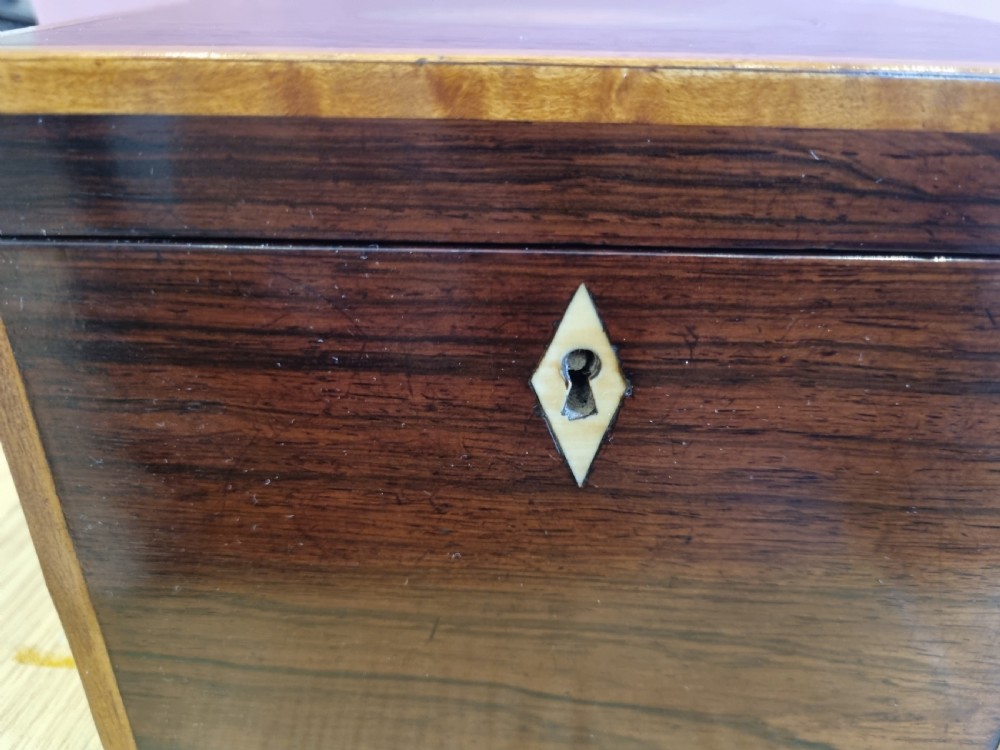 A rectangular dark rosewood tea caddy featuring a lid inlaid with an oval shell motif and a diamond-shaped bone keyhole escutcheon on the front face. View VII