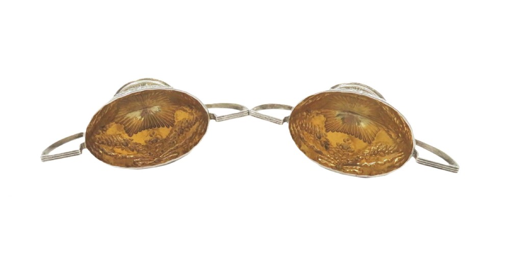 A pair of Victorian sterling silver open salt cellars featuring pedestal feet, double handles, embossed festoon decoration, and gilt interiors. View III