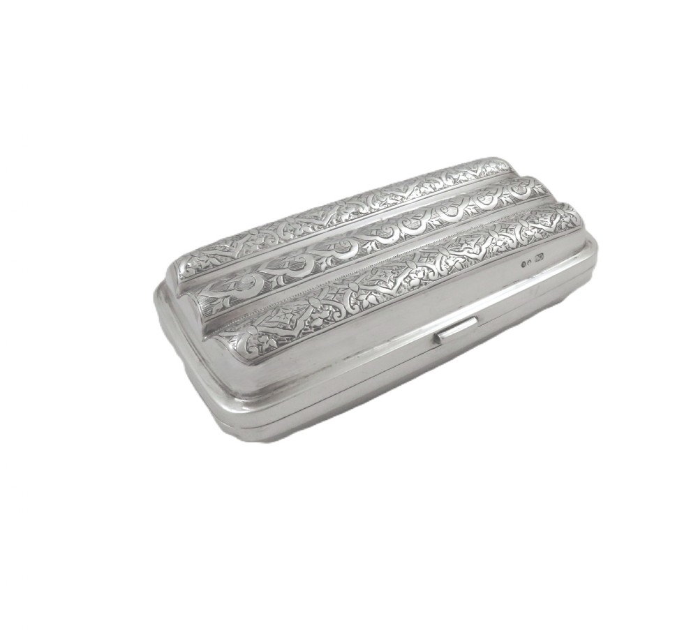 An engraved Victorian sterling silver cigar case featuring three contoured sections and intricate foliate patterns with stamped hallmarks. View IX