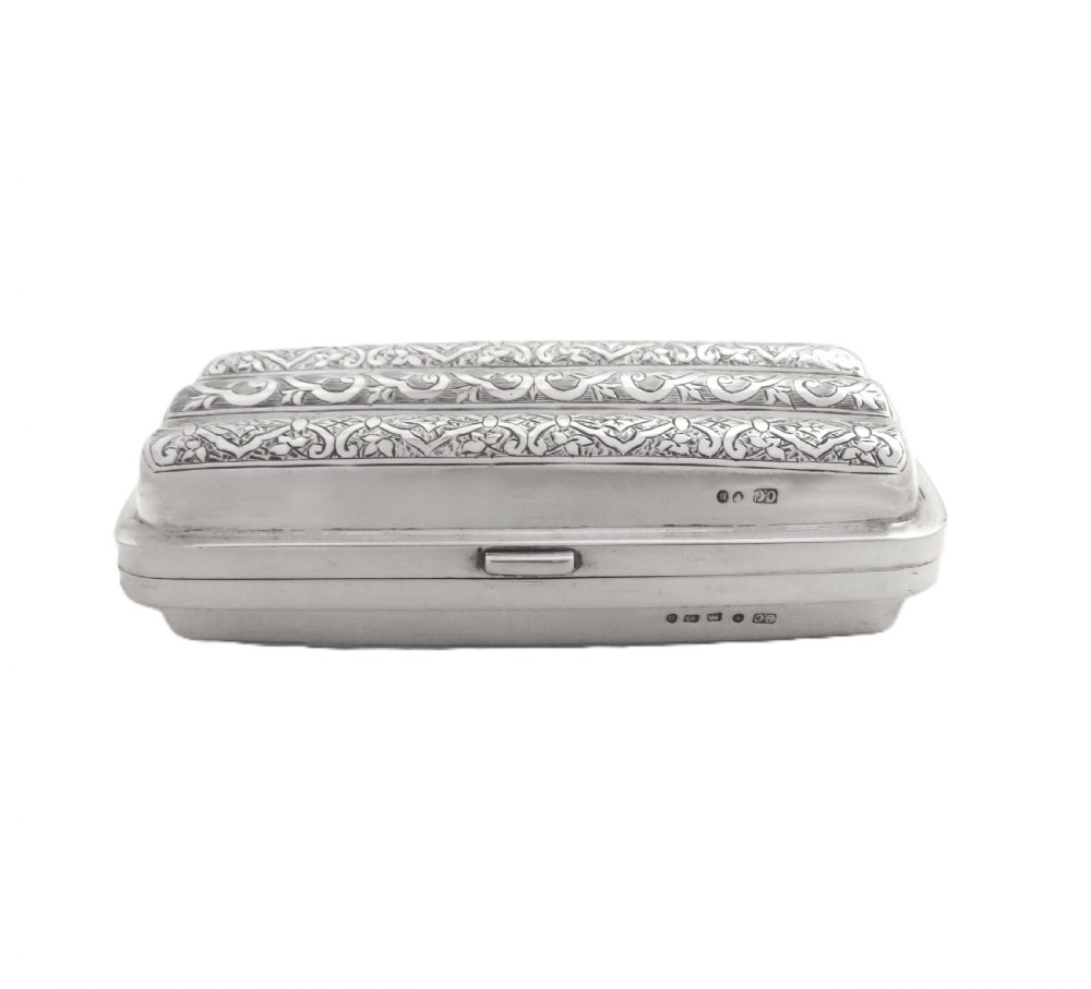 An engraved Victorian sterling silver cigar case featuring three contoured sections and intricate foliate patterns with stamped hallmarks. View X