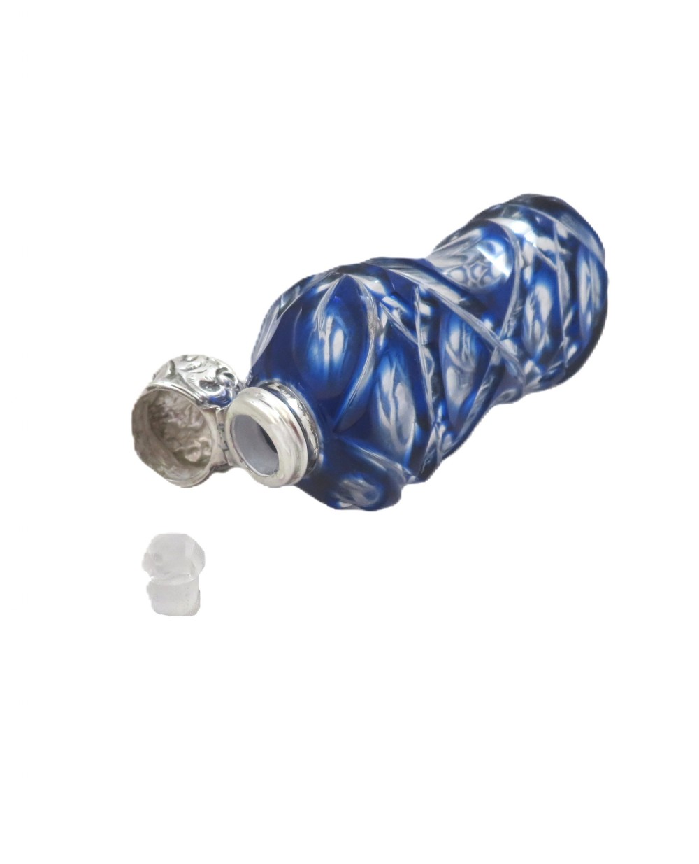 A Victorian cobalt blue overlay cut glass scent bottle featuring geometric cut patterns and an embossed silver cap. View III