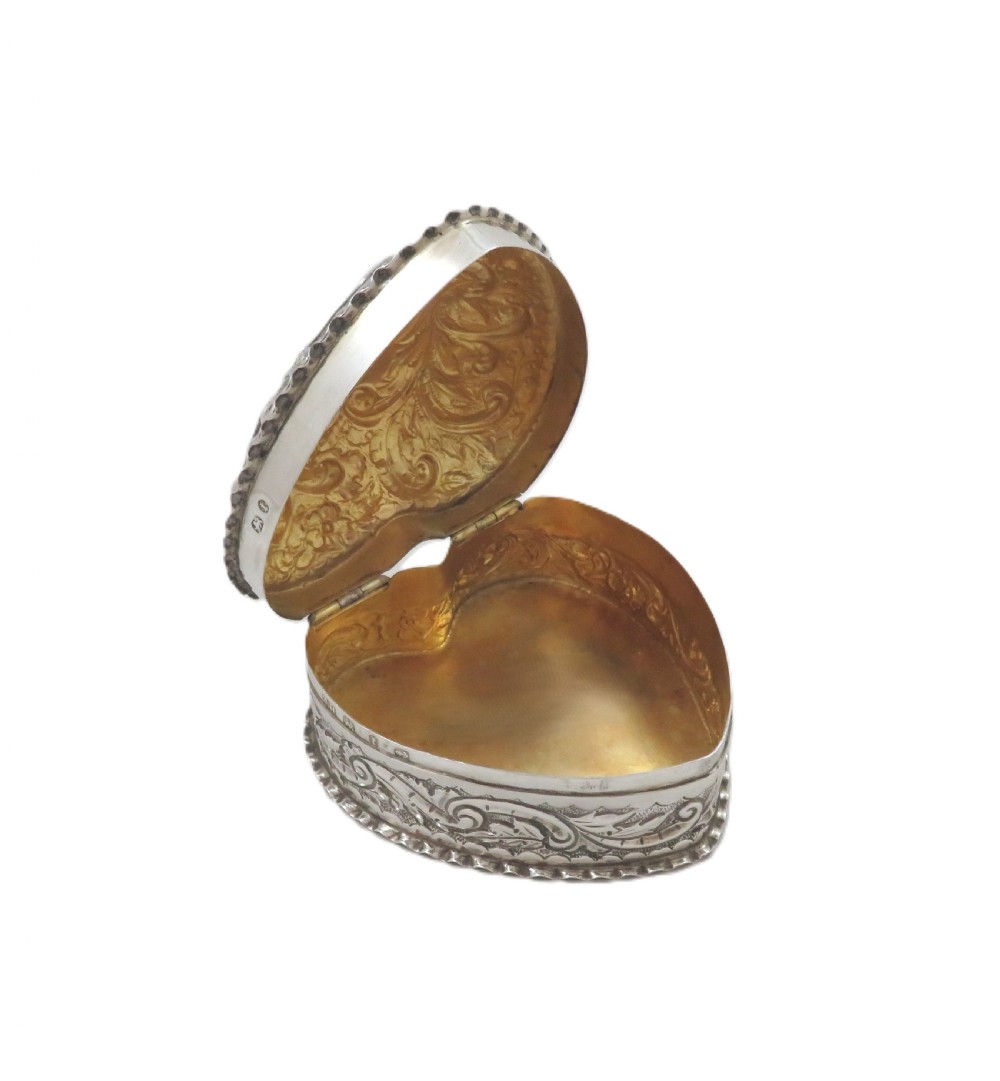A heart-shaped sterling silver trinket box featuring detailed acanthus scroll repousse work around a smooth central cartouche. View VII
