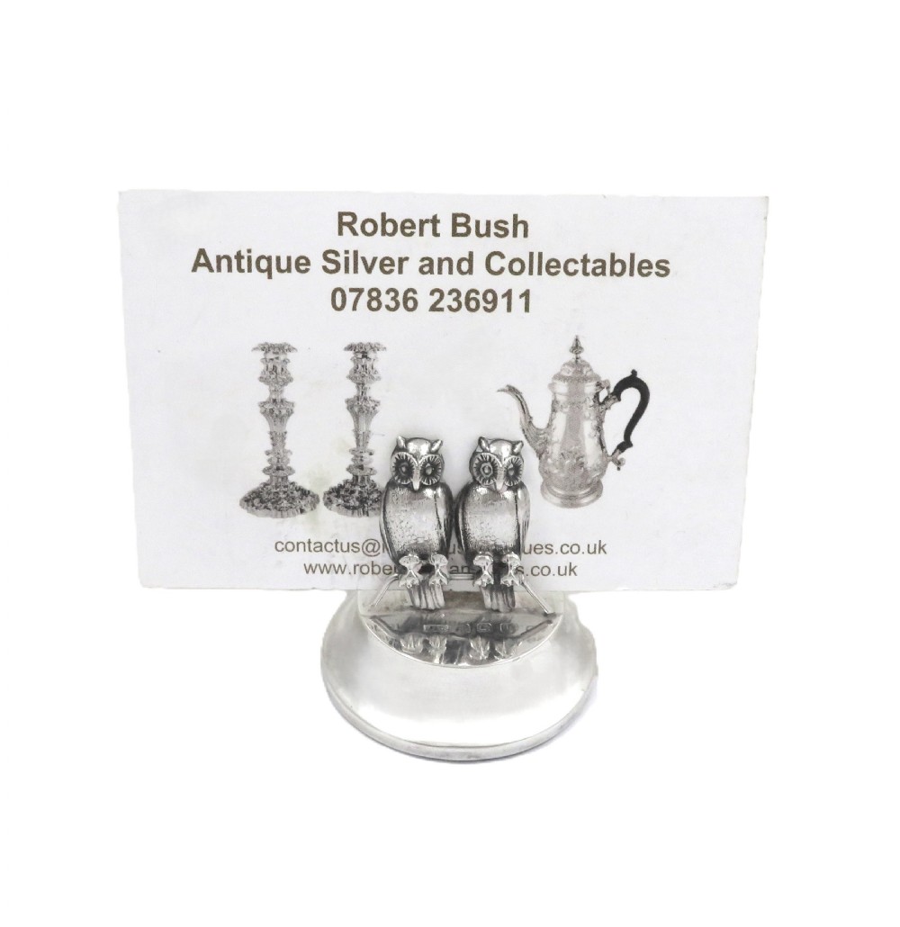 A pair of Edwardian sterling silver menu holders featuring double owl figures perched on round polished bases with visible silver hallmarks. View IV