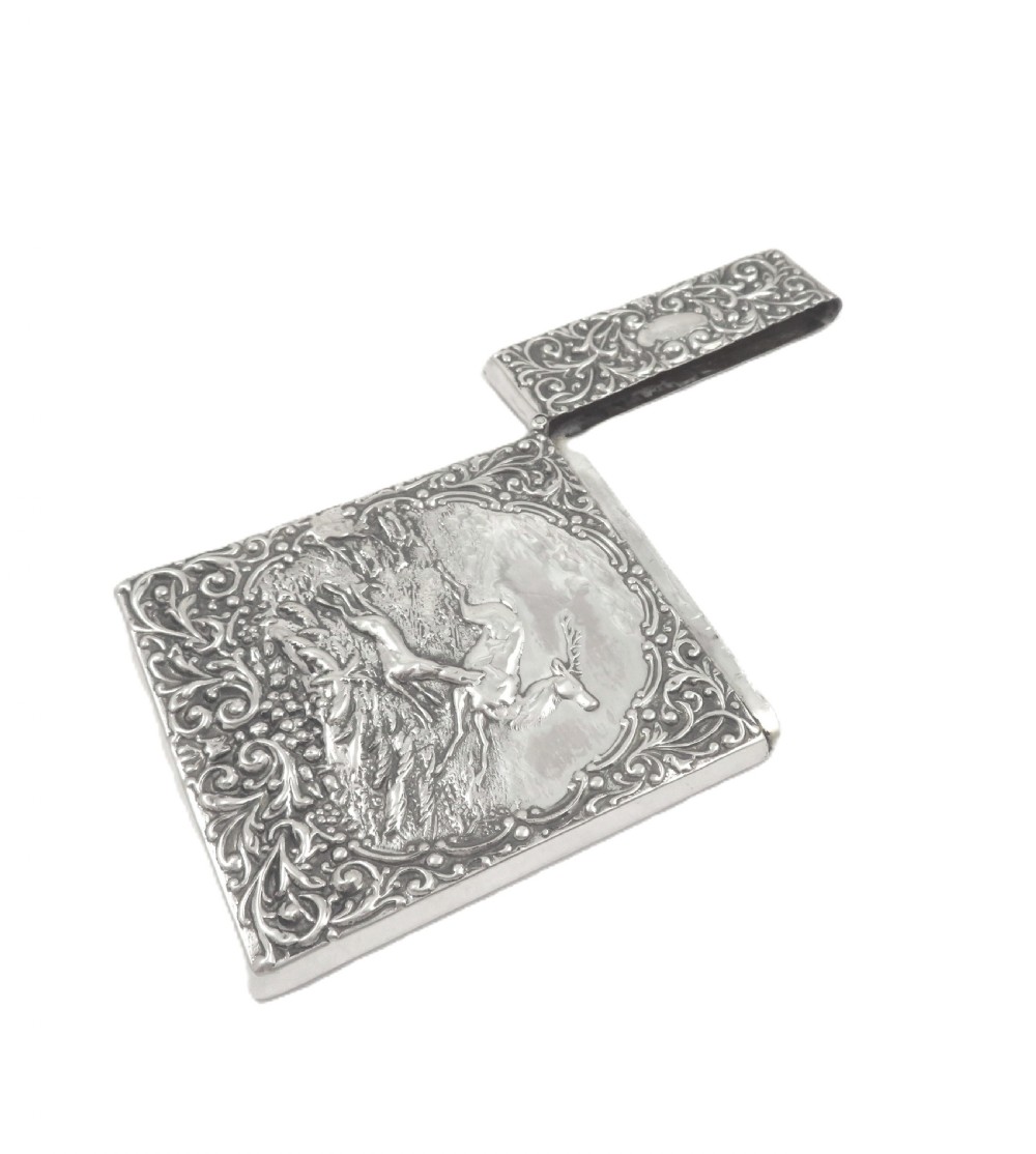 A rectangular Edwardian sterling silver card case decorated with repousse scrollwork and a central relief scene of a hound pursuing a stag. View III