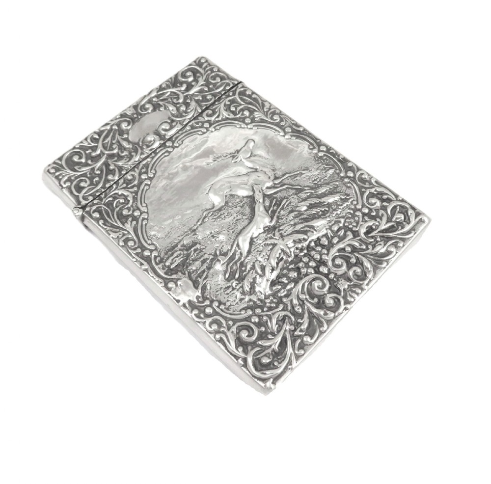 A rectangular Edwardian sterling silver card case decorated with repousse scrollwork and a central relief scene of a hound pursuing a stag. View VIII