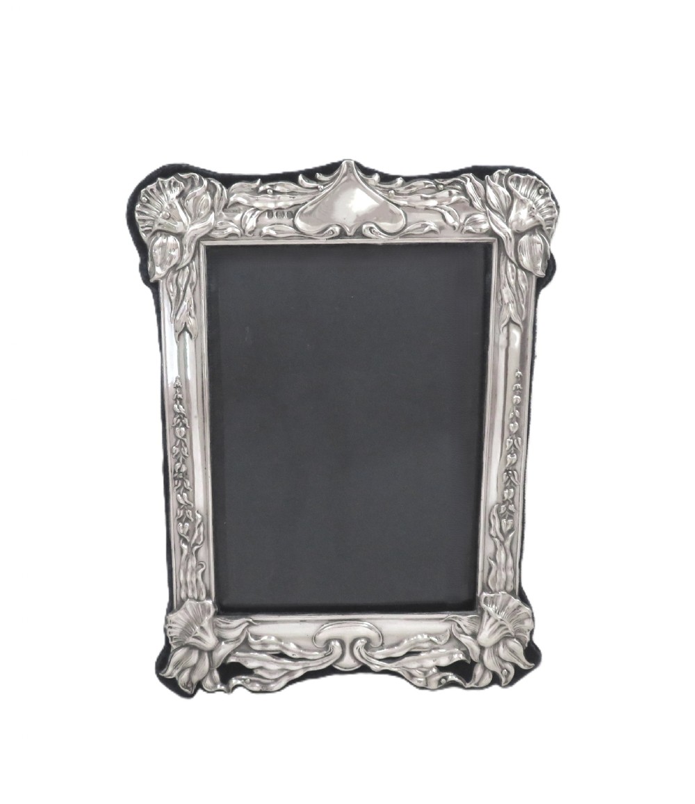 An embossed sterling silver Art Nouveau picture frame featuring stylised floral repousse motifs and a fabric-covered easel backing. View VIII
