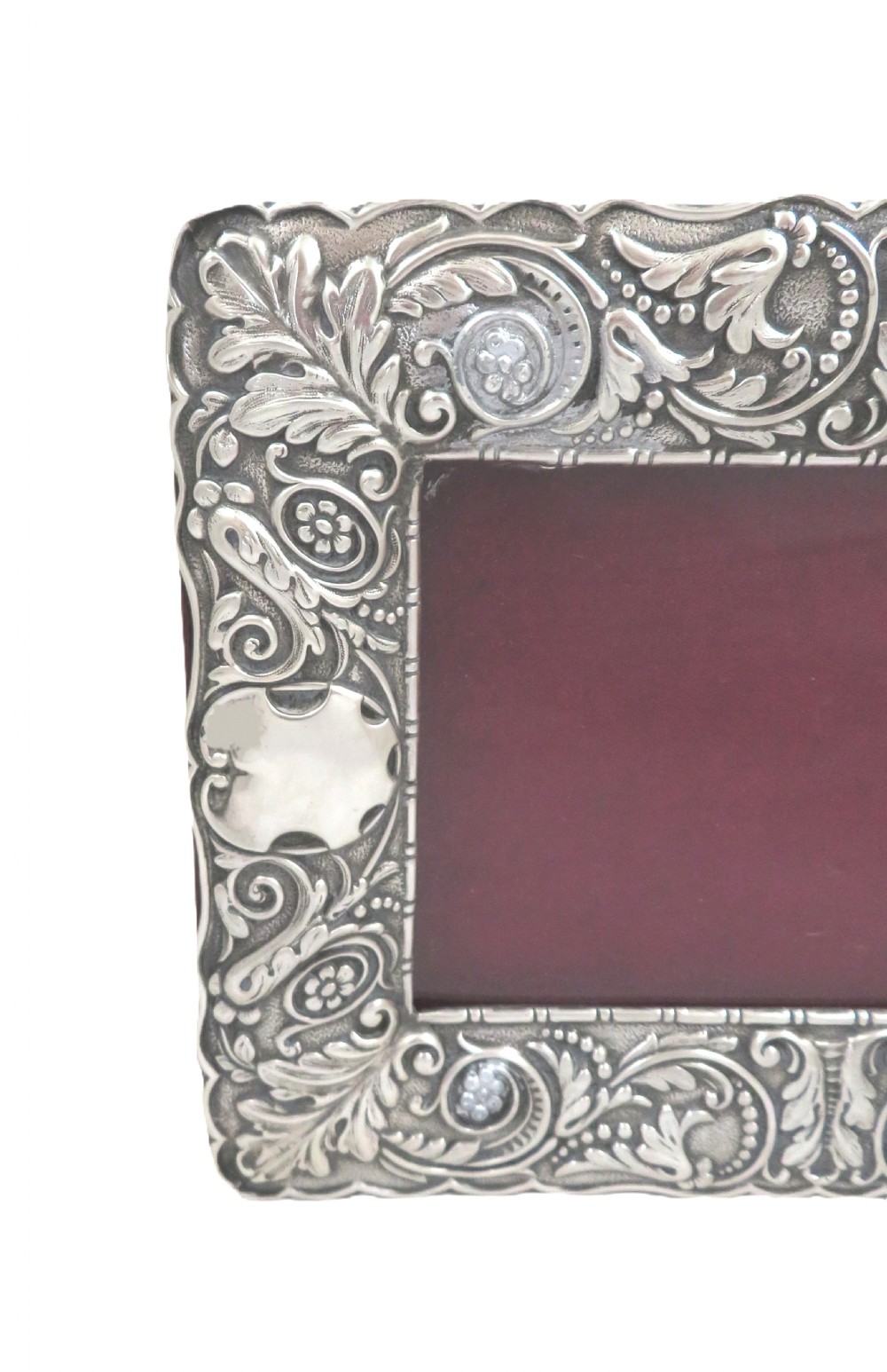 An Edwardian sterling silver landscape photo frame featuring repousse foliage motifs, a blank cartouche, and a dark velvet backing. View III