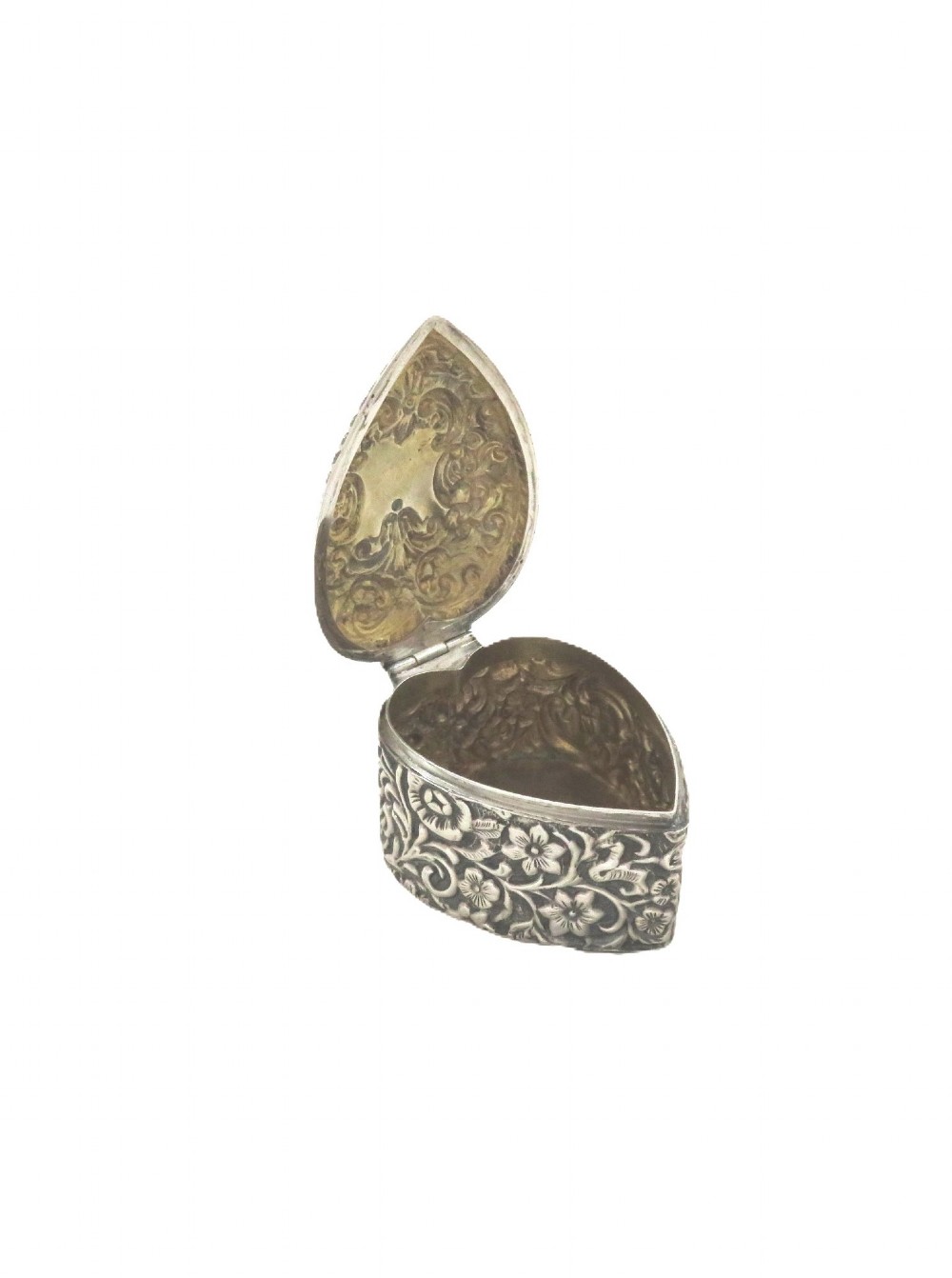 A heart-shaped sterling silver trinket box featuring intricate chased floral motifs and scrollwork. View V