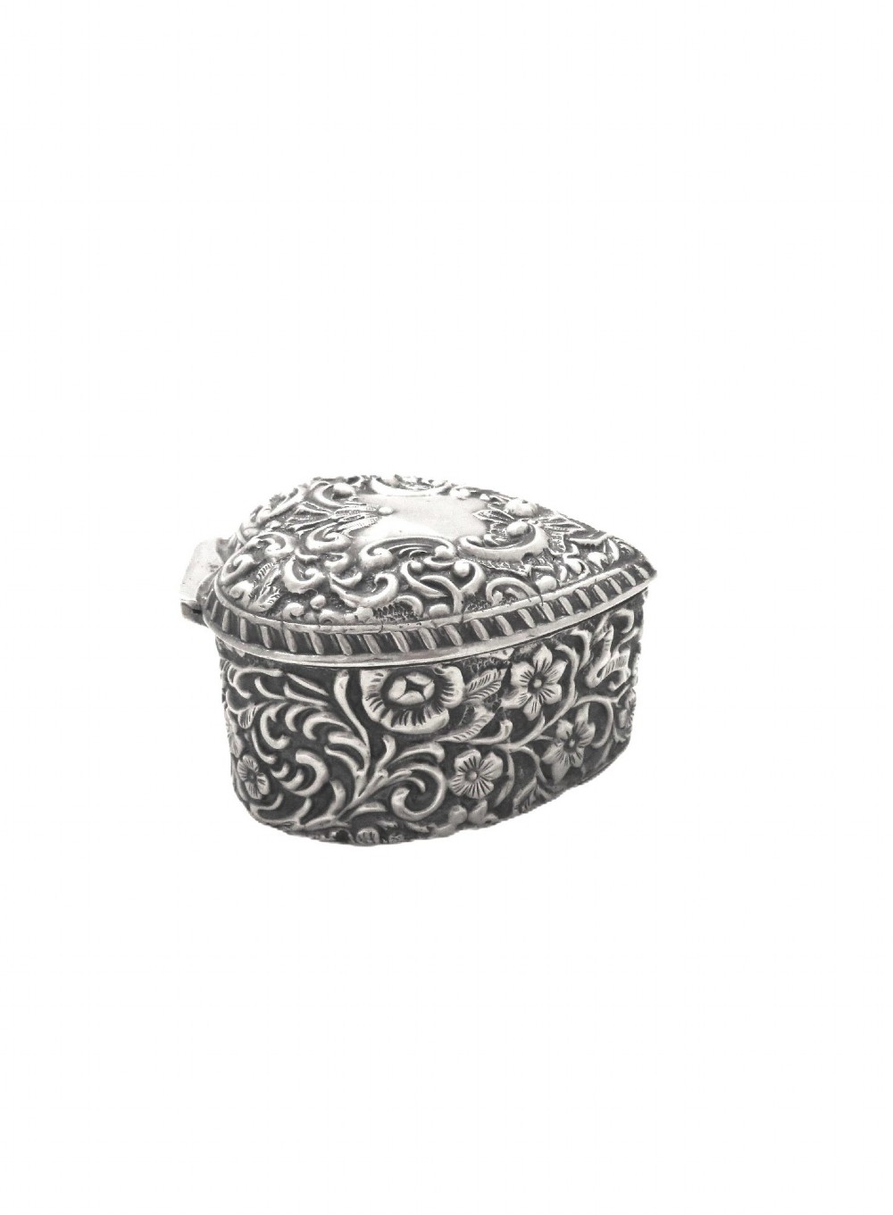 A heart-shaped sterling silver trinket box featuring intricate chased floral motifs and scrollwork. View VI