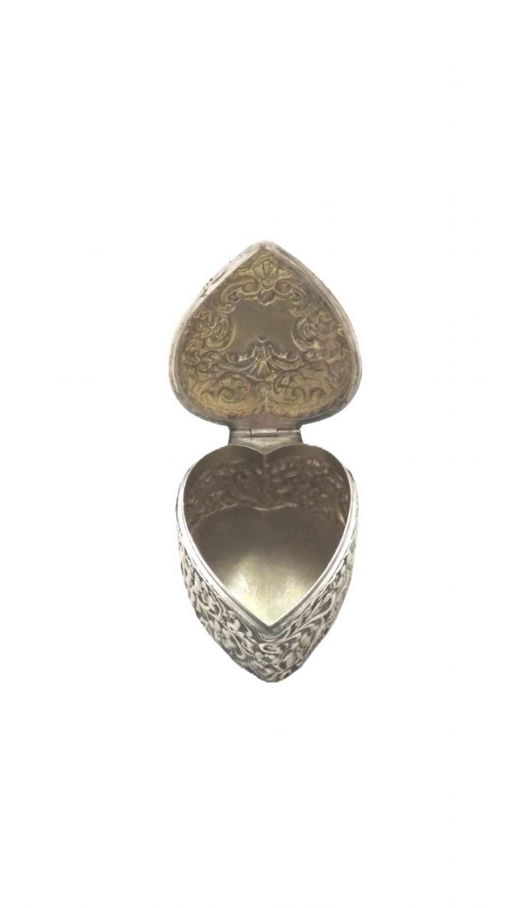 A heart-shaped sterling silver trinket box featuring intricate chased floral motifs and scrollwork. View VII