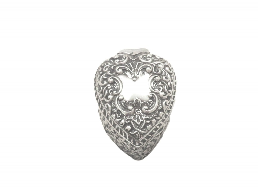 A heart-shaped sterling silver trinket box featuring intricate chased floral motifs and scrollwork. View IX