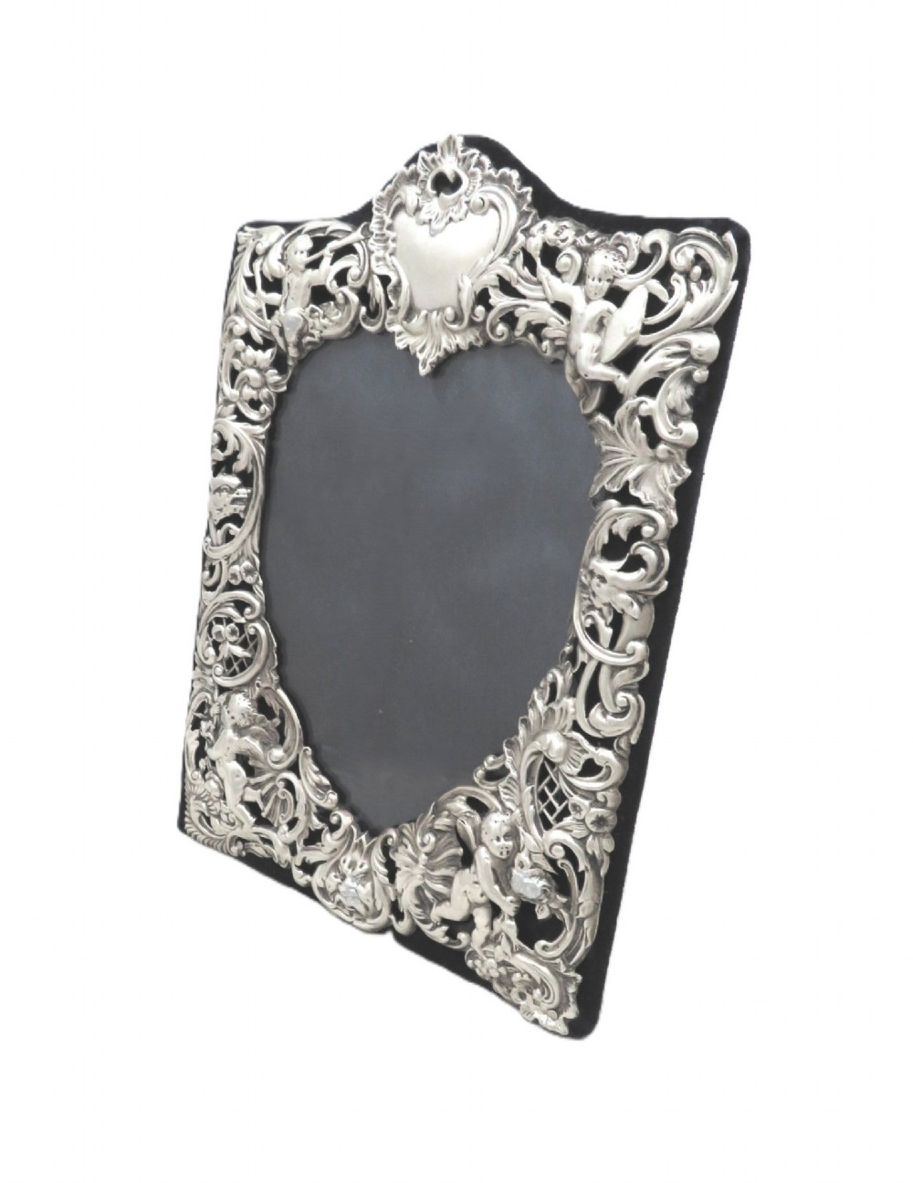 An antique Victorian sterling silver easel photo frame featuring a heart-shaped central opening surrounded by embossed cherubs, foliate scrolls, and a blank top cartouche. View VI