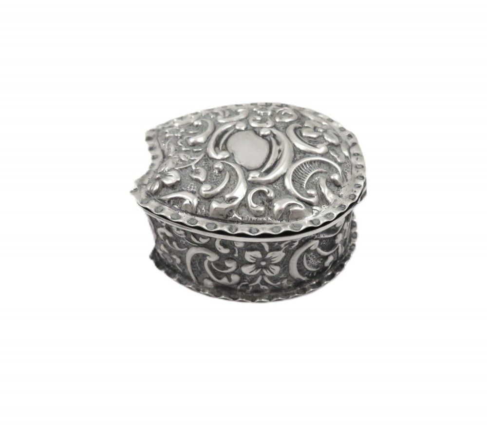 A small horseshoe-shaped sterling silver trinket box featuring embossed floral scrollwork and a central vacant cartouche. View IV