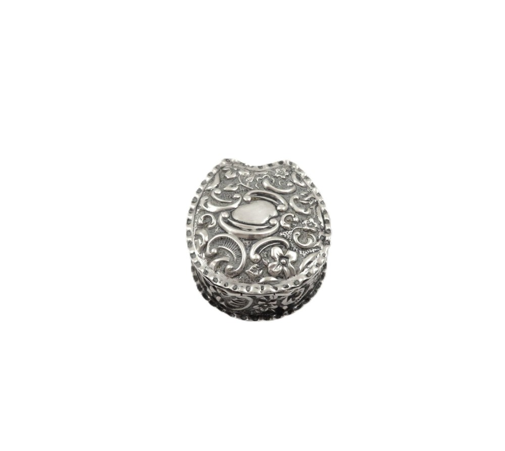 A small horseshoe-shaped sterling silver trinket box featuring embossed floral scrollwork and a central vacant cartouche. View VIII
