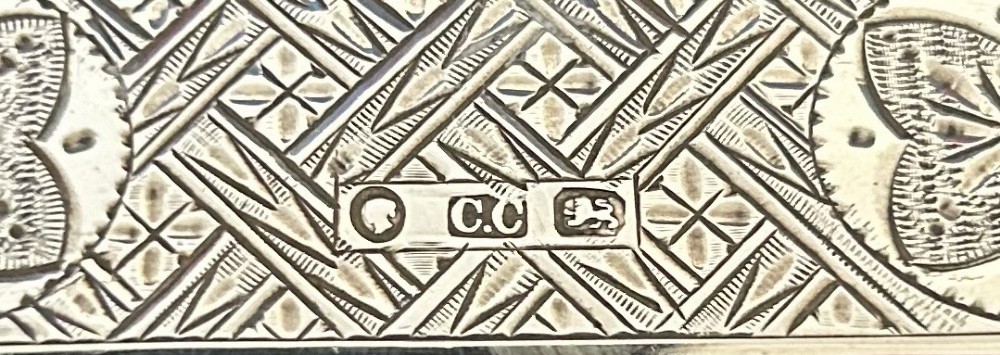 An antique Victorian sterling silver card case featuring geometric engine turning, floral engraving, and British silver hallmarks. View VII