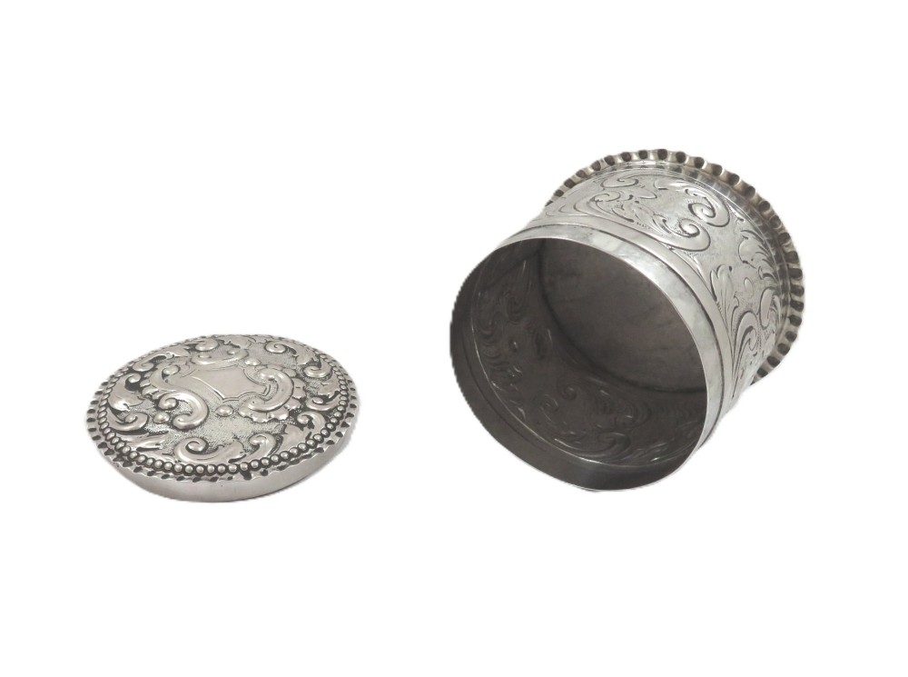 A small cylindrical Victorian sterling silver vanity pot decorated with floral repousse scrollwork and a beaded rim around the lid. View III