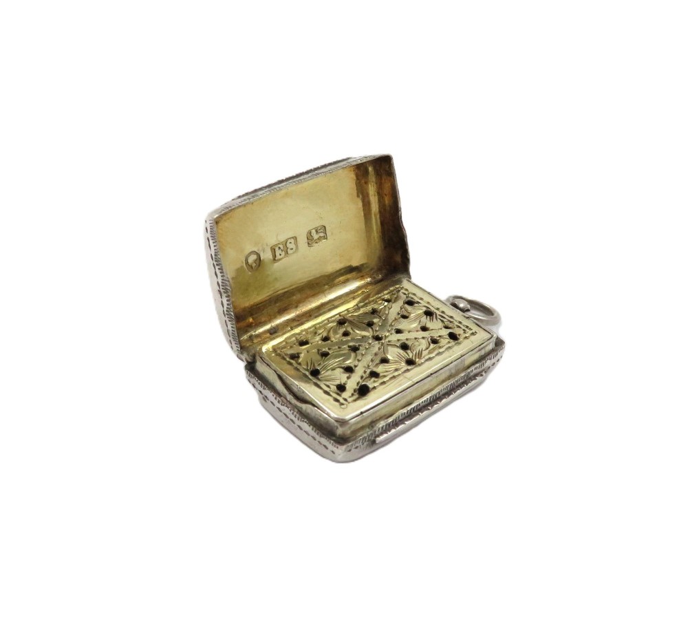 An antique rectangular sterling silver vinaigrette featuring foliate scroll engraving and an attached suspension loop. View III
