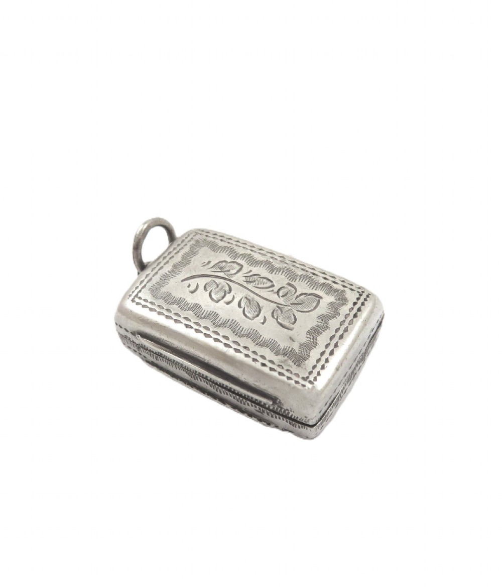 An antique rectangular sterling silver vinaigrette featuring foliate scroll engraving and an attached suspension loop. View IV