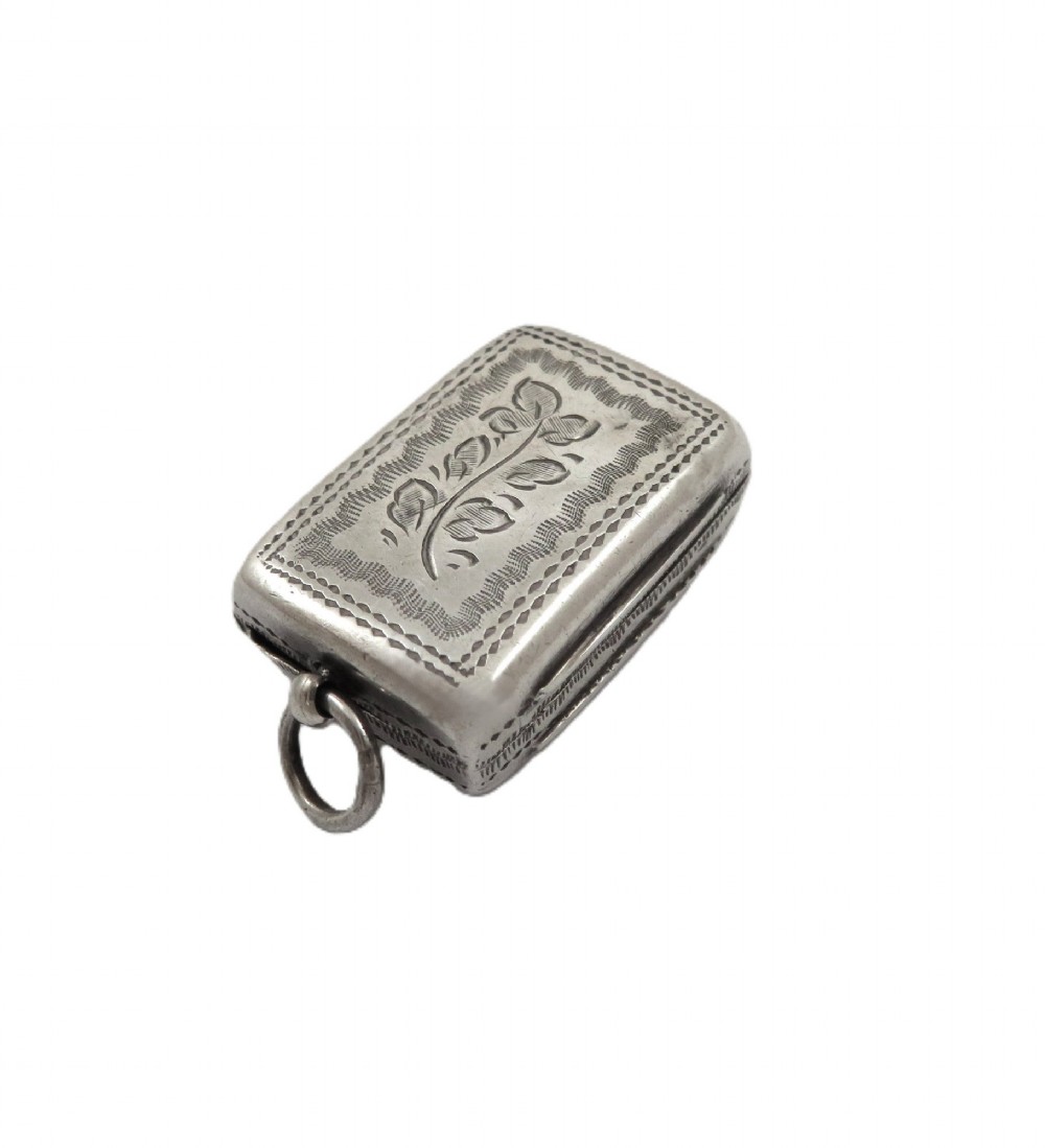An antique rectangular sterling silver vinaigrette featuring foliate scroll engraving and an attached suspension loop. View VIII