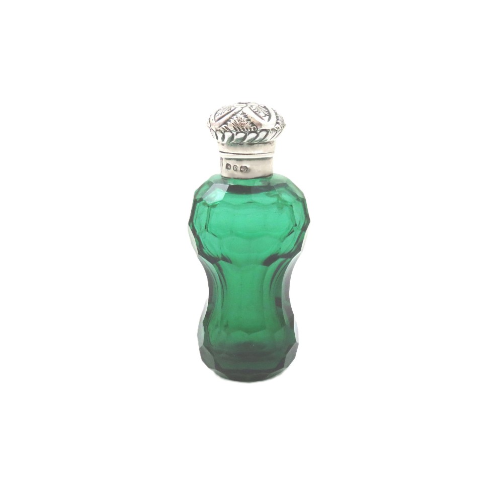 A late Victorian faceted green cut glass scent bottle featuring an engraved sterling silver collar and cap.