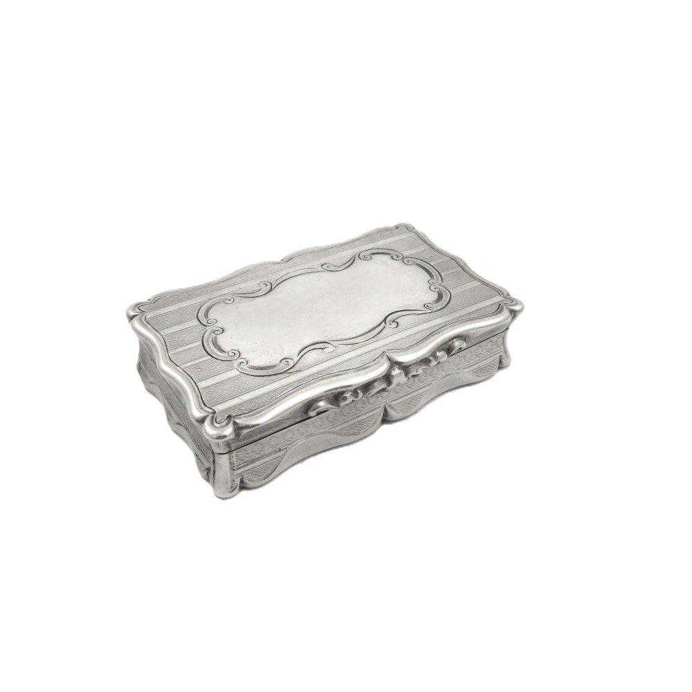 A rectangular Victorian sterling silver snuff box featuring scalloped edges, engine-turned linear engraving, and an unengraved scrollwork cartouche on the lid.