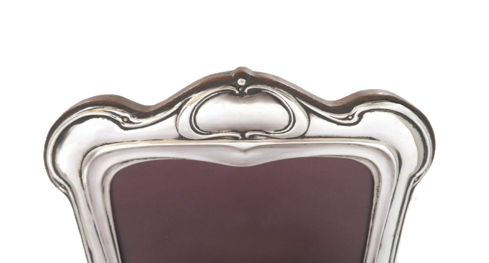 An Art Nouveau sterling silver photo frame with sinuous, organic border detailing and a dark backing. View III