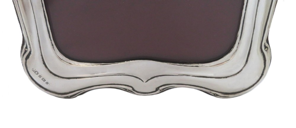An Art Nouveau sterling silver photo frame with sinuous, organic border detailing and a dark backing. View VI