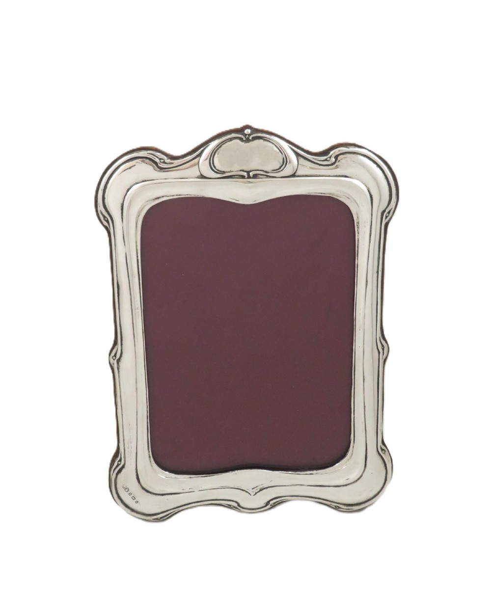 An Art Nouveau sterling silver photo frame with sinuous, organic border detailing and a dark backing. View VII