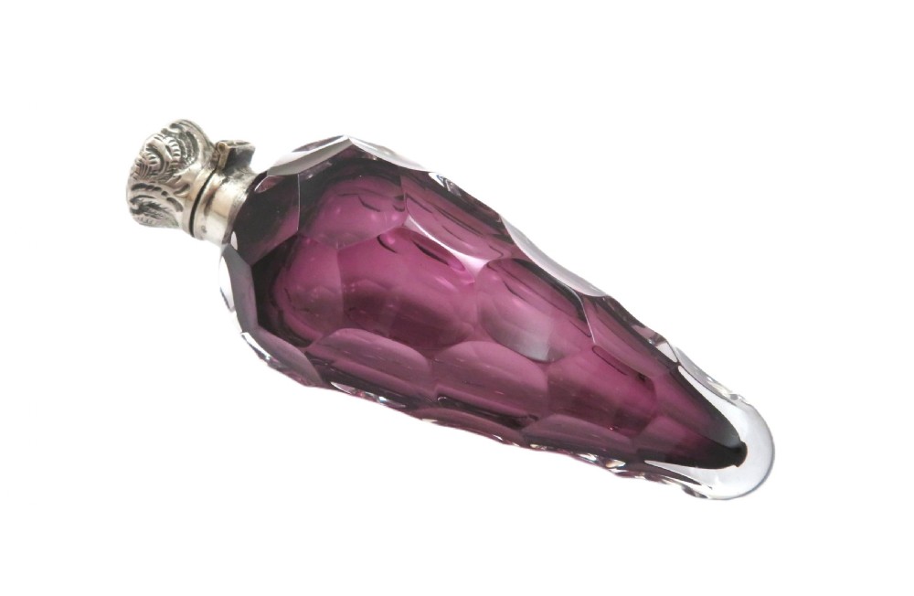 A late Victorian faceted amethyst glass scent bottle featuring an embossed sterling silver collar and top. View V