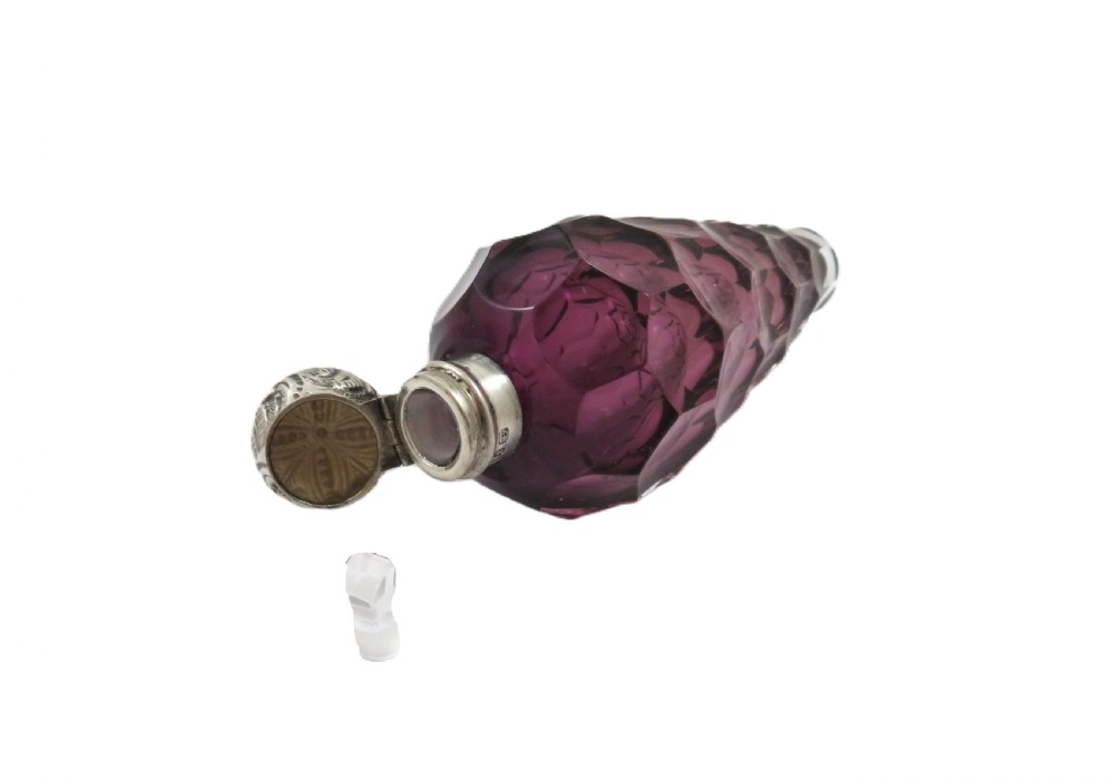 A late Victorian faceted amethyst glass scent bottle featuring an embossed sterling silver collar and top. View VI
