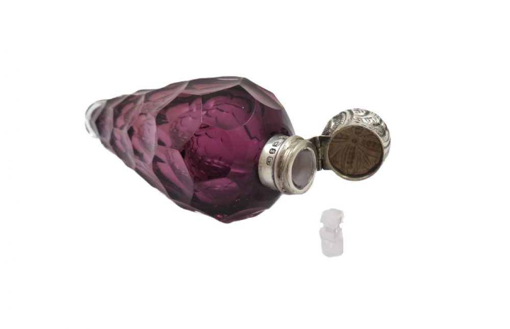 A late Victorian faceted amethyst glass scent bottle featuring an embossed sterling silver collar and top. View VIII
