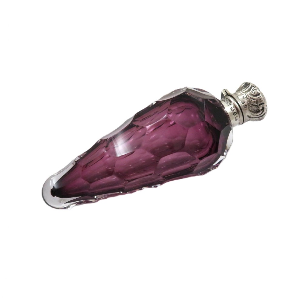 A late Victorian faceted amethyst glass scent bottle featuring an embossed sterling silver collar and top. View IX