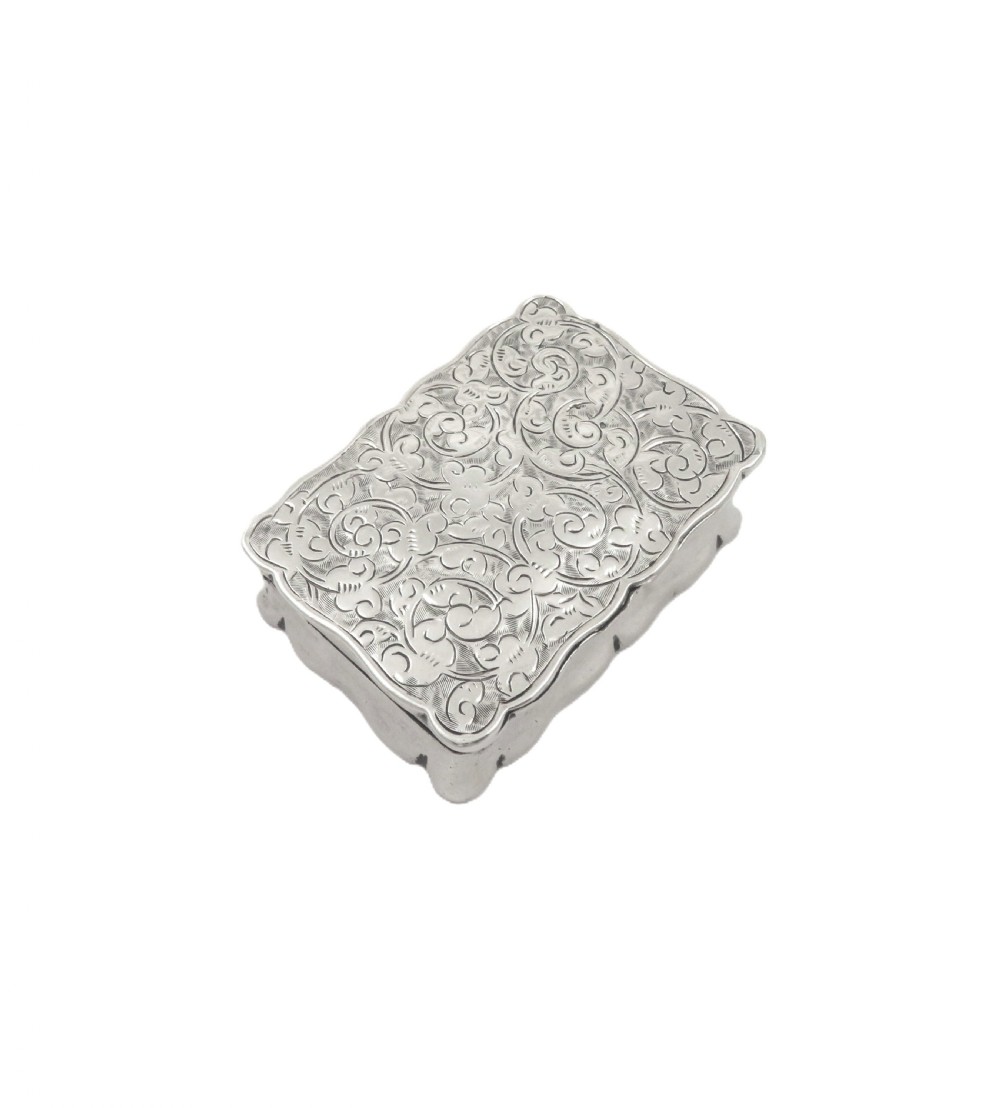 An antique Victorian rectangular sterling silver box featuring chased floral scrollwork and a central engraved crest on the lid. View VIII