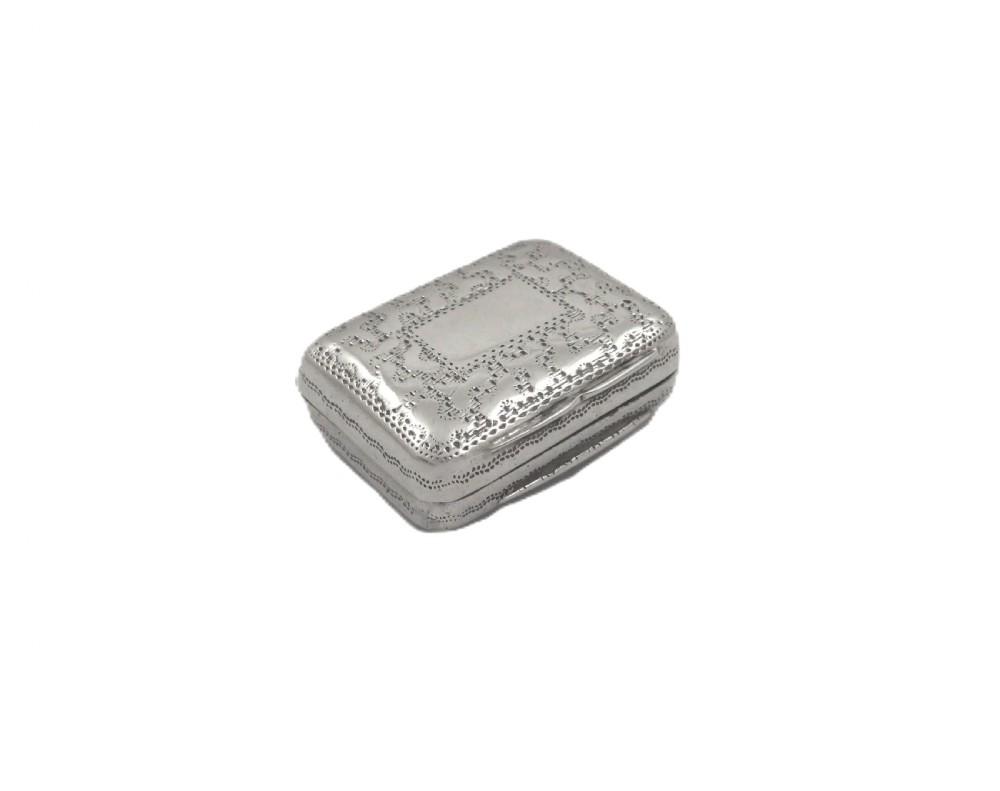 A small rectangular Georgian sterling silver vinaigrette box with detailed surface engraving and a central unengraved cartouche.