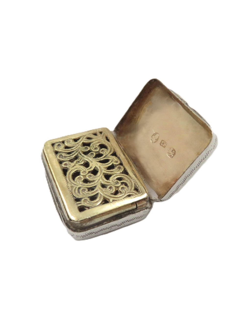 A small rectangular Georgian sterling silver vinaigrette box with detailed surface engraving and a central unengraved cartouche. View VIII