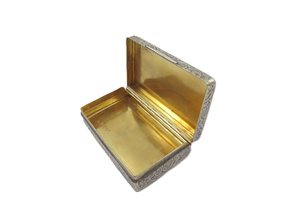 Rectangular sterling silver snuff box featuring intricate hand-engraved scrollwork and a central armorial cartouche on the hinged lid. View IV