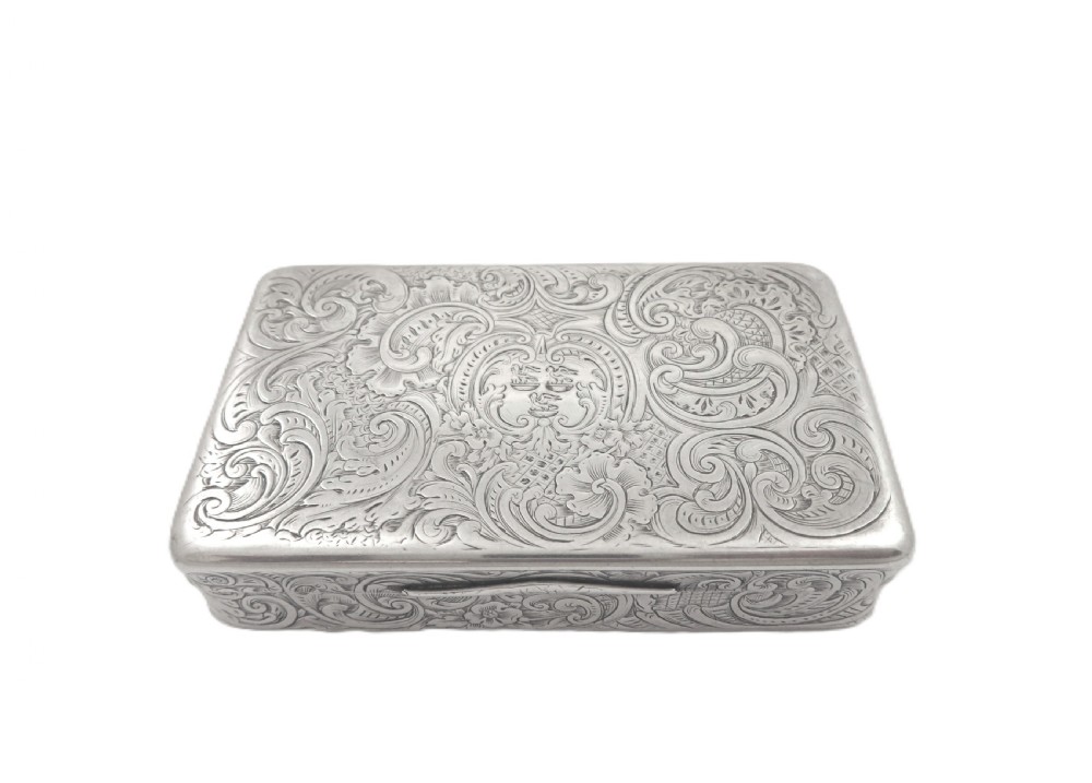 Rectangular sterling silver snuff box featuring intricate hand-engraved scrollwork and a central armorial cartouche on the hinged lid. View V