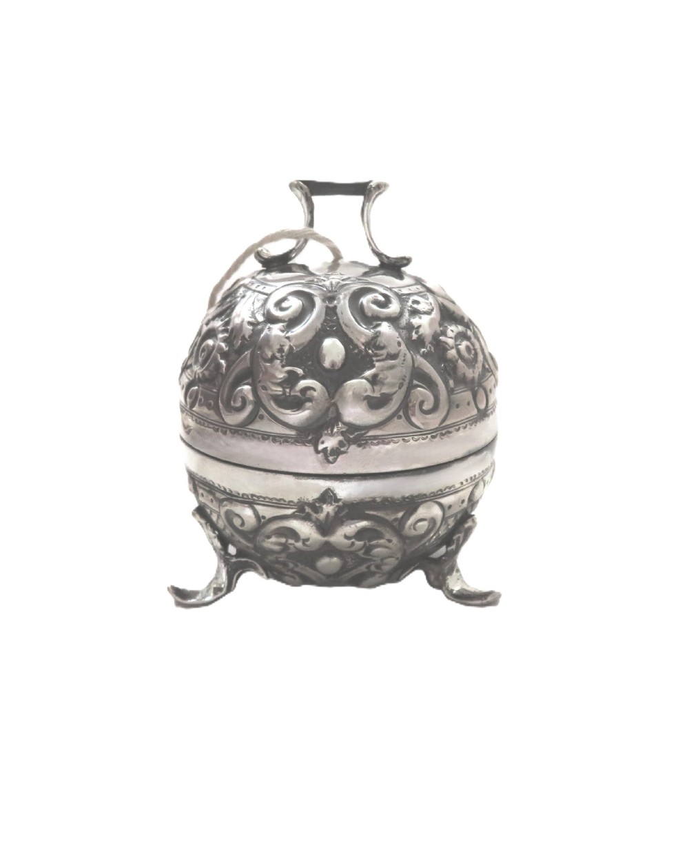 A spherical Victorian sterling silver string box with elaborate repousse scroll ornamentation, resting on three scroll feet. View VI